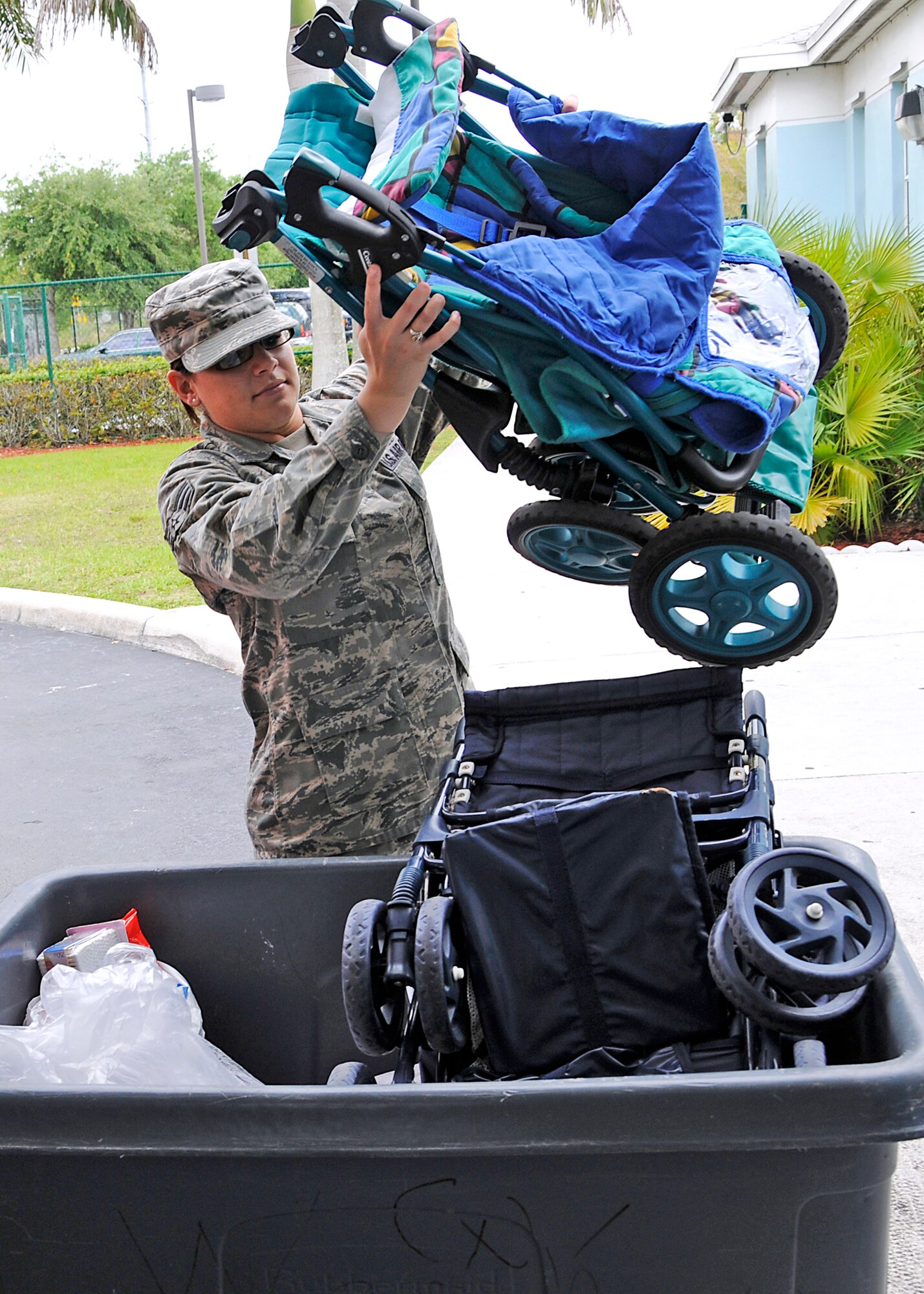 Senior Airman Astrid Lopez-Michelen, Junior Enlisted Council member at  Homestead Air Reserve Base, Fla., places donated strollers into a cart at the Homestead Community Partnership for Homeless. The JEC, a base program comprised of junior enlisted service members, have been collecting much needed donations for the shelter and donated their haul on Saturday May 1. (U.S. Air Force photo/Senior Airman Lou Burton)