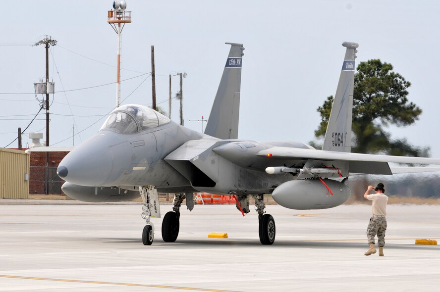 A Crew Chief from the 125th Fighter Wing marshals an F-15 into place following a sortie, Combat Readiness Training Center (CRTC), Savannah, GA, March 10, 2010. The 125th Fighter Wing's deployment to Savannah CRTC was a rare opportunity for our F-15 pilots to fly Large Force Employment missions (LFE's), with other units and for wing members to build camaraderie on and off duty. (Air Force Photo by Tech. Sgt. Shelley Gill)