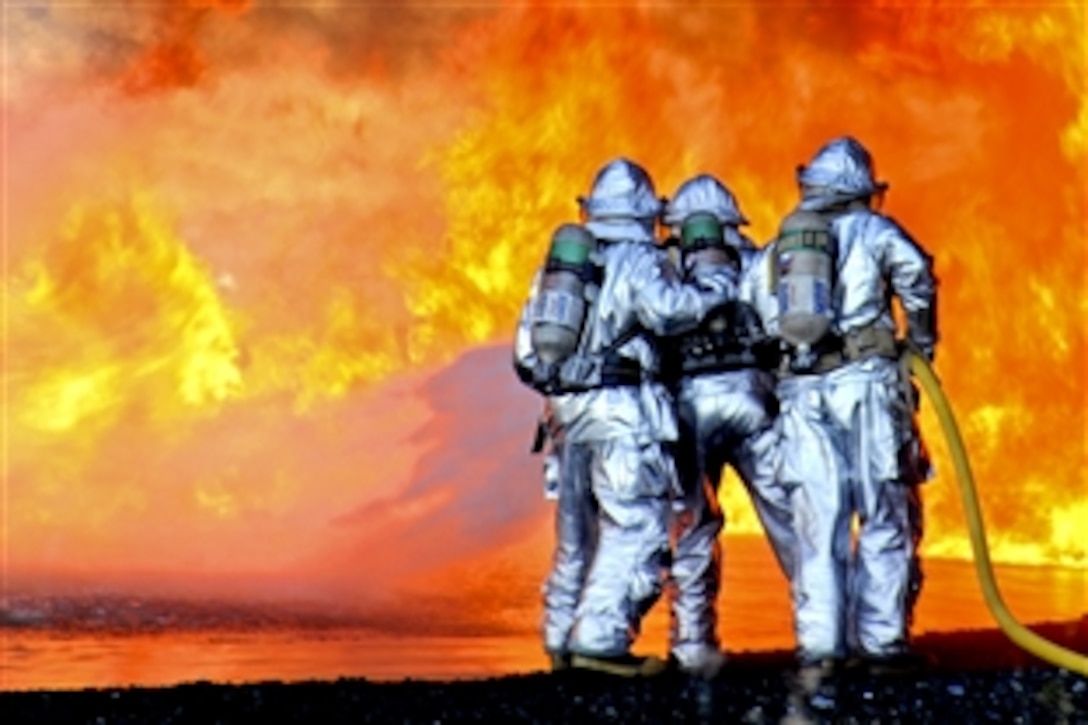 Firefighters conduct training on the U.S. Coast Guard base in Kodiak, Alaska, May 4, 2010, after fuel was pumped into a specialized pit of water to simulate an aircraft burn. The Kodiak base fire department was the 2009 Coast Guard Fire Department of the Year and consists of 32 firefighters.