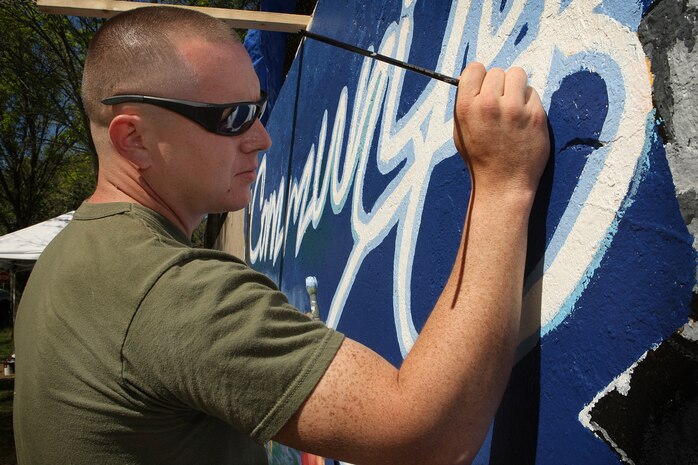 U. S. Marine Corps Lance Cpl. Pablo Morrison, Combat Reproduction Specialist, Marine Corps Base Quantico, Va., paints a Marine Corps themed mural at Hyde Park, Boston in support of Marine Week Boston, May 5, 2010. Marine Week Boston provides an opportunity to increase public awareness of the Marine Corps' value to our nation's defense and to preserve and mature the Corps' relationship with the American people.