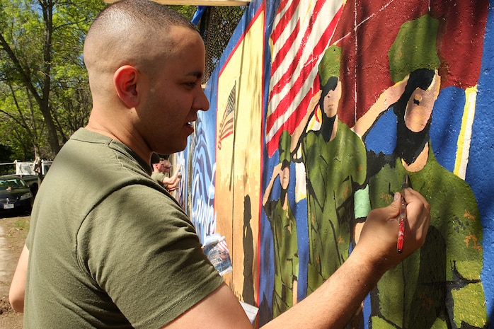 U. S. Marine Corps Cpl. Kristofer Atkinson, Combat Photographer, 4th Marine Corps Recruiting District, Recruiting Station New Cumberland, Pa., paints a Marine Corps themed mural at Hyde Park, Boston in support of Marine Week Boston, May 5, 2010. Marine Week Boston provides an opportunity to increase public awareness of the Marine Corps' value to our nation's defense and to preserve and mature the Corps' relationship with the American people.