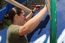 U. S. Marine Corps Cpl. Erin Carpenter, Marine Forces Reserve, Mobilization Command, New Orleans, La., paints a Marine Corps themed mural at Hyde Park in support of Marine Week Boston, May 5, 2010. Marine Week Boston provides an opportunity to increase public awareness of the Marine Corps' value to our nation's defense and to preserve and mature the Corps' relationship with the American people.