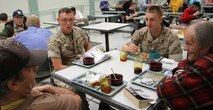Cpl. Robert Mabry and Lance Cpl. Tyler Robinson enjoy a moment with veterans over lunch at the New England Center for Homeless Veterans May 5, 2010. Squads of Marines from 3rd Battalion, 24th Marine Regiment, kicked off Marine Week Boston by participating in a community outreach project May 3-5.  Breaking into teams, the Marines were able to tackle an array of projects that were waiting to be addressed but haven't been accomplished within a restricted $6 million budget.