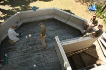 U. S. Marine Corps Lance Cpl. Trevor Salyer (left) and Corporals Jonathan Brimshaw (center) and Mikel Hensley (right) of 3rd Battalion, 24th Marines, Johnson City, Tenn., clean the back patio during a project to help renovate the Robert J. Watson House, in Cambridge, Mass., in support of Marine Week Boston, May 5, 2010. Once Renovated, the Robert J. Watson House will be used as a shelter for troubled youth females. (Official U. S. Marine Corps photo by Lance Cpl. Natasha J. Combs)