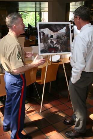 Sgt. Kristopher J. Battles, the combat artist with the National Museum of the Marine Corps, talks to retired Army Brig. Gen. Kevin T. Ryan, the senior fellow of the John F. Kennedy School of Government for Harvard University, about his art, May 5, 2010.