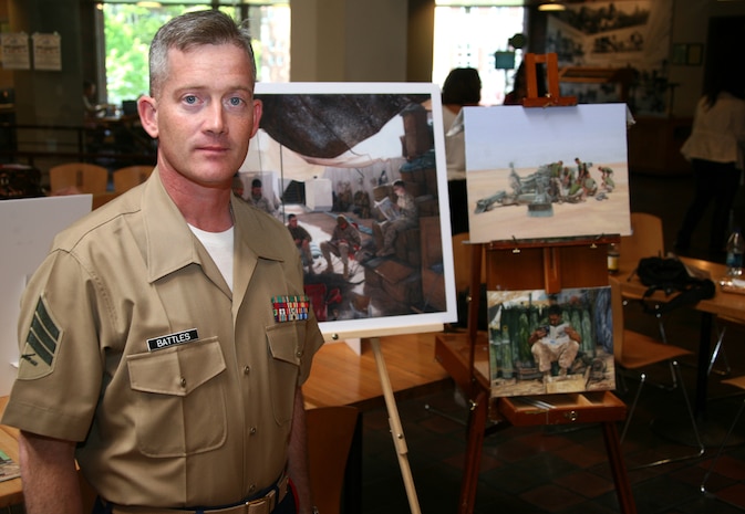 Sgt. Kristopher J. Battles, the combat artist with the National Museum of the Marine Corps, stands in front of his paintings, May 5, 2010, at the John F. Kennedy School of Government for Harvard University. Battles showed several paintings, sketches and portraits for residents and tourists to see the artwork of a combat artist, in Cambridge, Mass., to help tell the Marine Corps story during Marine Week.