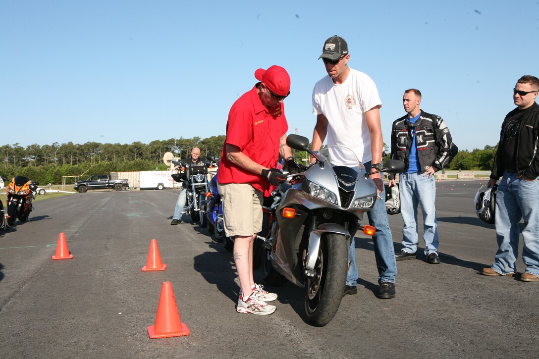 Staff Sgt. Brent M. Sharp (left) the motorcycle safety officer with Combat Logistics Regiment 27, 2nd Marine Logistics Group, along with Master Sgt. Charles “Chuck” Barden (right) the intelligence operations chief with Headquarters Battalion, 2nd Marine Division, offered technical and safety support to participants of the Advanced Rider Track Day, May 6, 2010, at the Auxiliary Landing Field Bogue, N.C. The event’s purpose was to train the participants and make them more aware of their bike’s limitations and how to prevent accidents.