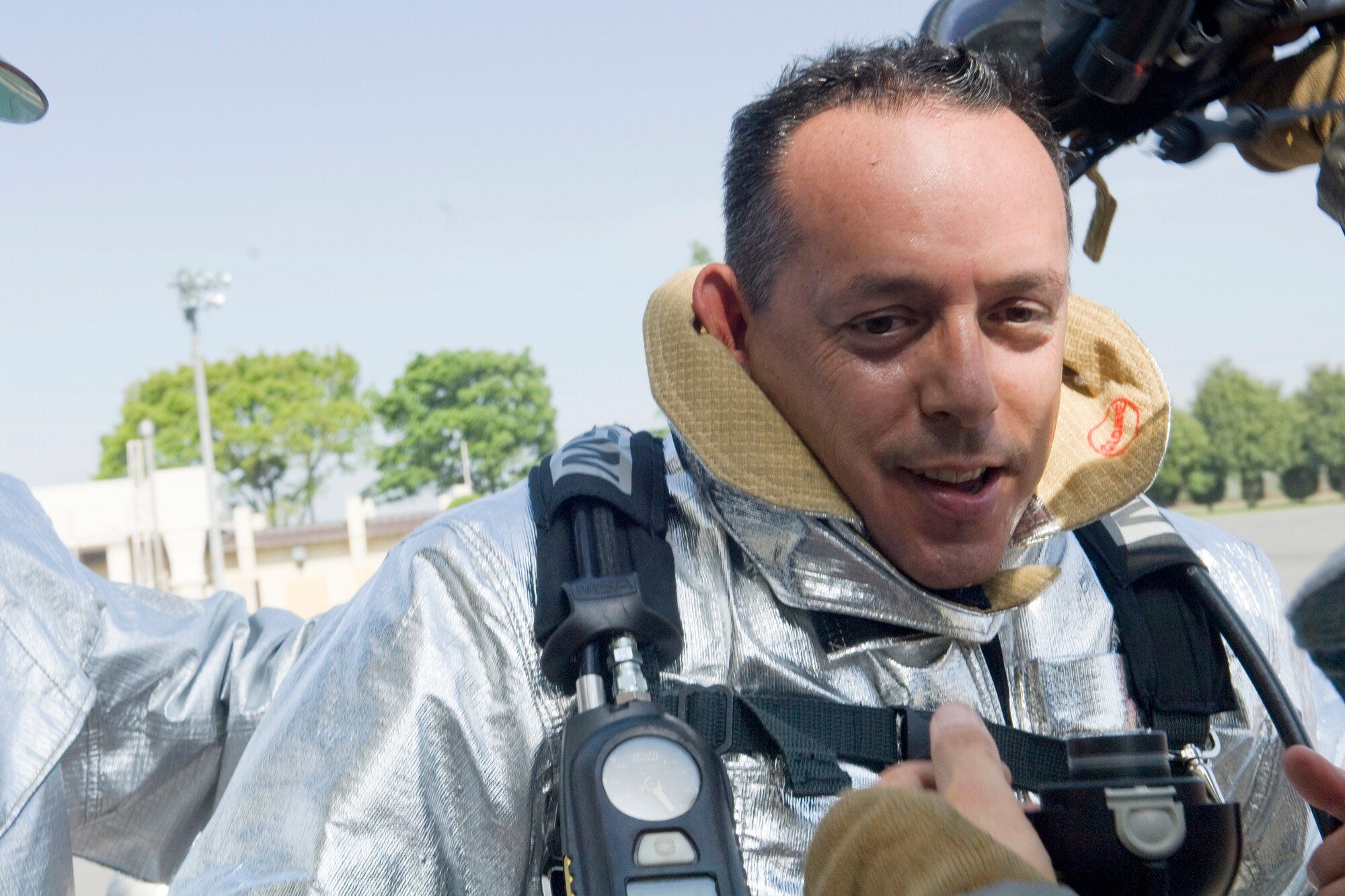 YOKOTA AIR BASE, Japan -- Col. Rafael Quezada, 374th Mission Support Group commander, just completes a firefighting training and removes firefighting gears here 06 May. The 374th Civil Engineer Squadron and Fire Emergency Services Flight invites Col. Quezada to a simulated live fire structural exercise focusing on challenges firefighters encounter during real world situations. (U.S. Air Force photo/Osakabe Yasuo)