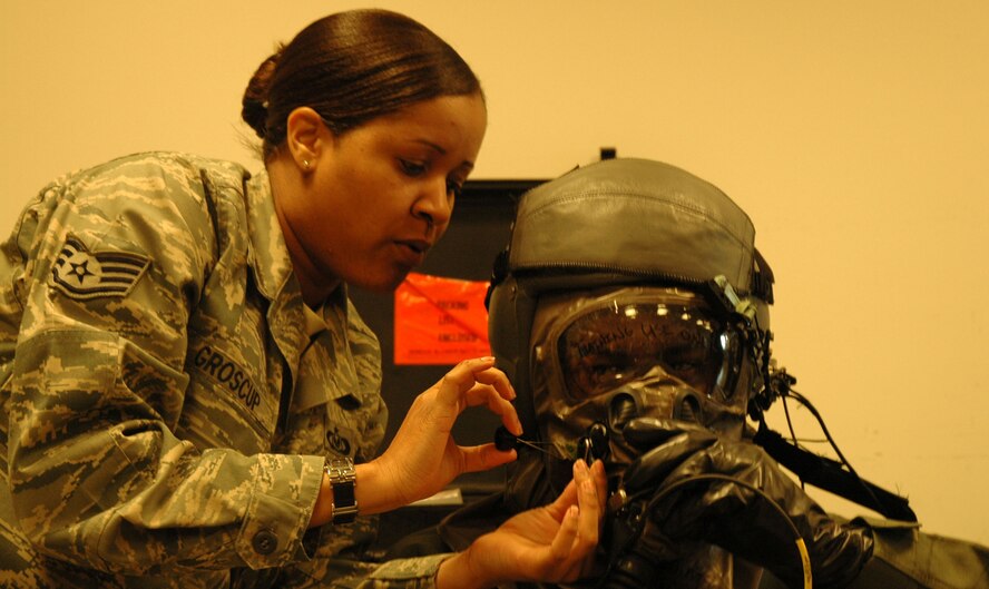 JOINT BASE LEWIS-MCCHORD, Wash.- Staff Sgt. Patrina Groscup, training monitor, 62nd Operations Support Squadron Aircrew Life Support Flight, fastens the tabs on the Aircrew Eye Respiratory Protection System (AERPS) equipment while emphasizing the importance of wearing the equipment as instructe. This was part of the Hire America's Heroes civic leader tour and symposium, McChord Field here, May 6.  The theme of this year's event was "Breaking Down Barriers to Veteran Employment," to help corporate leaders and businesses in Washington State understand how veterans can benefit their business or organization. The guests also flew aboard a C-17 Globemaster III aircraft and toured the Maintenance Field Training Detachment.(U.S. Air Force Photo/Staff Sgt. Nicole Celestine)