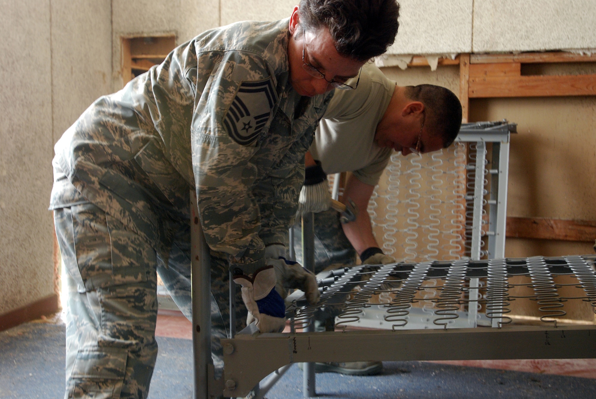 A group of visiting chief master sergeants, command chief master sergeants and first sergeants from all over Air Force Reserve Command and military trainign instructors from the 433rd Training Squadron, Lackland Air Force Base, Texas, assemble bunks in a WWII-era former dormatory, which will be part of the Air Force History and Traditions Museum here. The building was moved from the site of new housing and trainign facilities being built, escaping demolition. (U.S. Air Force photo/Airman 1st Class Brian McGloin)