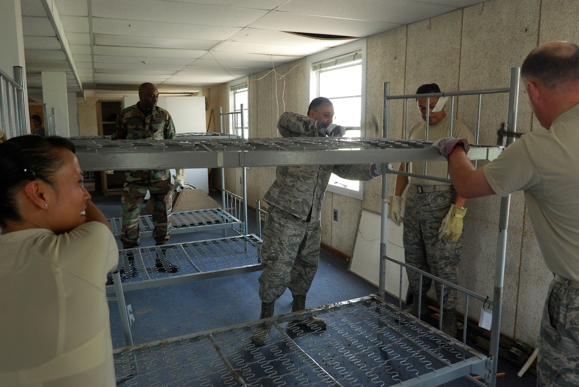 A group of visiting chief master sergeants, command chief master sergeants and first sergeants from all over Air Force Reserve Command and military trainign instructors from the 433rd Training Squadron, Lackland Air Force Base, Texas, assemble bunks in a WWII-era former dormatory, which will be part of the Air Force History and Traditions Museum here. The building was moved from the site of new housing and trainign facilities being built, escaping demolition. (U.S. Air Force photo/Airman 1st Class Brian McGloin)