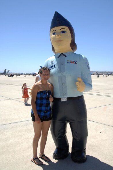 An AirFest fan poses with a giant Airman at the March Field AirFest, March Air Reserve Base, Calif., May 1, 2010. March Field AirFest is a two-day event featuring performances and static displays of civilian and military aircraft. (U.S. Air Force photo by Senior Master Sgt. Kim Allain/Released)