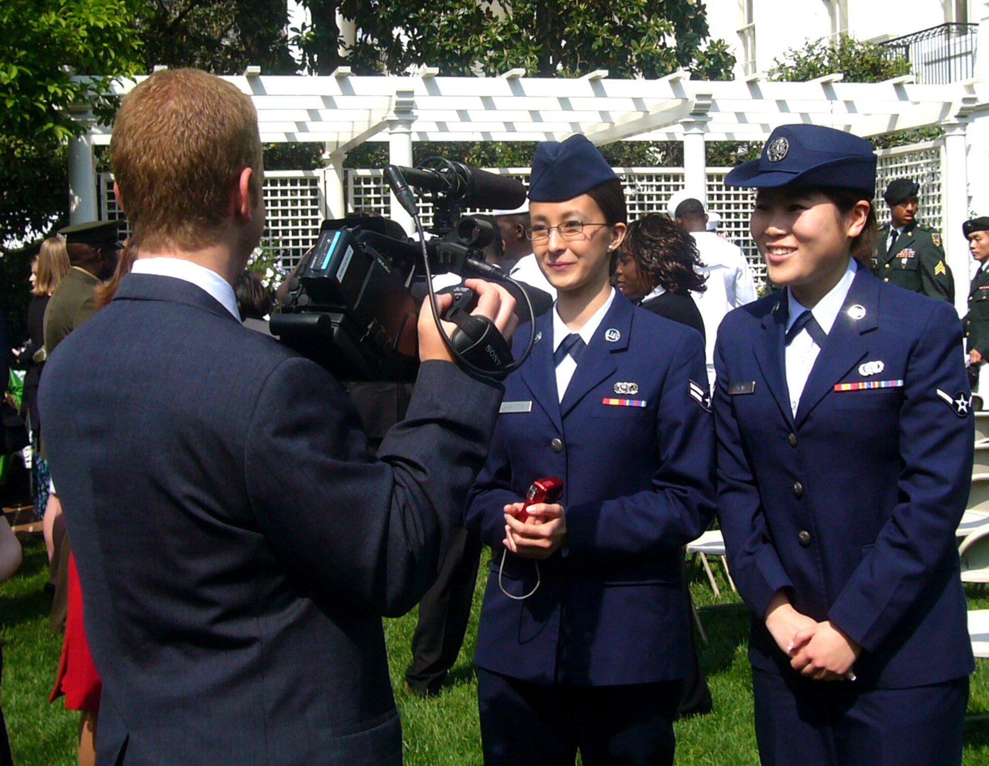 Airman 1st Class Ma Antonette Cabantog and Airman Yu Yuan perform an interview at the Oath of Allegiance ceremony at the White House April 23. The Airmen joined 22 other servicemembers in taking the Oath of Allegiance, becoming American citizens. Airman Cabantog is a 633rd Force Support Squadron food services journeyman. Airman Yuan is a 735th Supply Chain Management Group mission capability apprentice. (Courtesy photo)