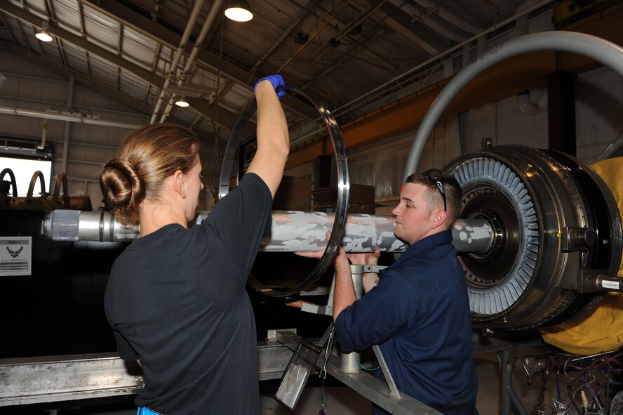 SEYMOUR JOHNSON AIR FORCE BASE N.C. -- Airman 1st Class Katherine Bouldin and Staff Sgt. Michael Lundy assemble a low pressure turbine module to an F-100-220E jet engine here May 5, 2010. When these Airmen receive a broken engine they tear it down, repair it and rebuild it. Airman Bouldin and Sergeant Lundy are both 4th Component Maintenance Squadron jet engine mechanics. Airman Bouldin hails from San Antonio and Sergeant Lundy is a native of Hillsborough. (U.S Air Force photo/Airman 1st Class Gino Reyes)