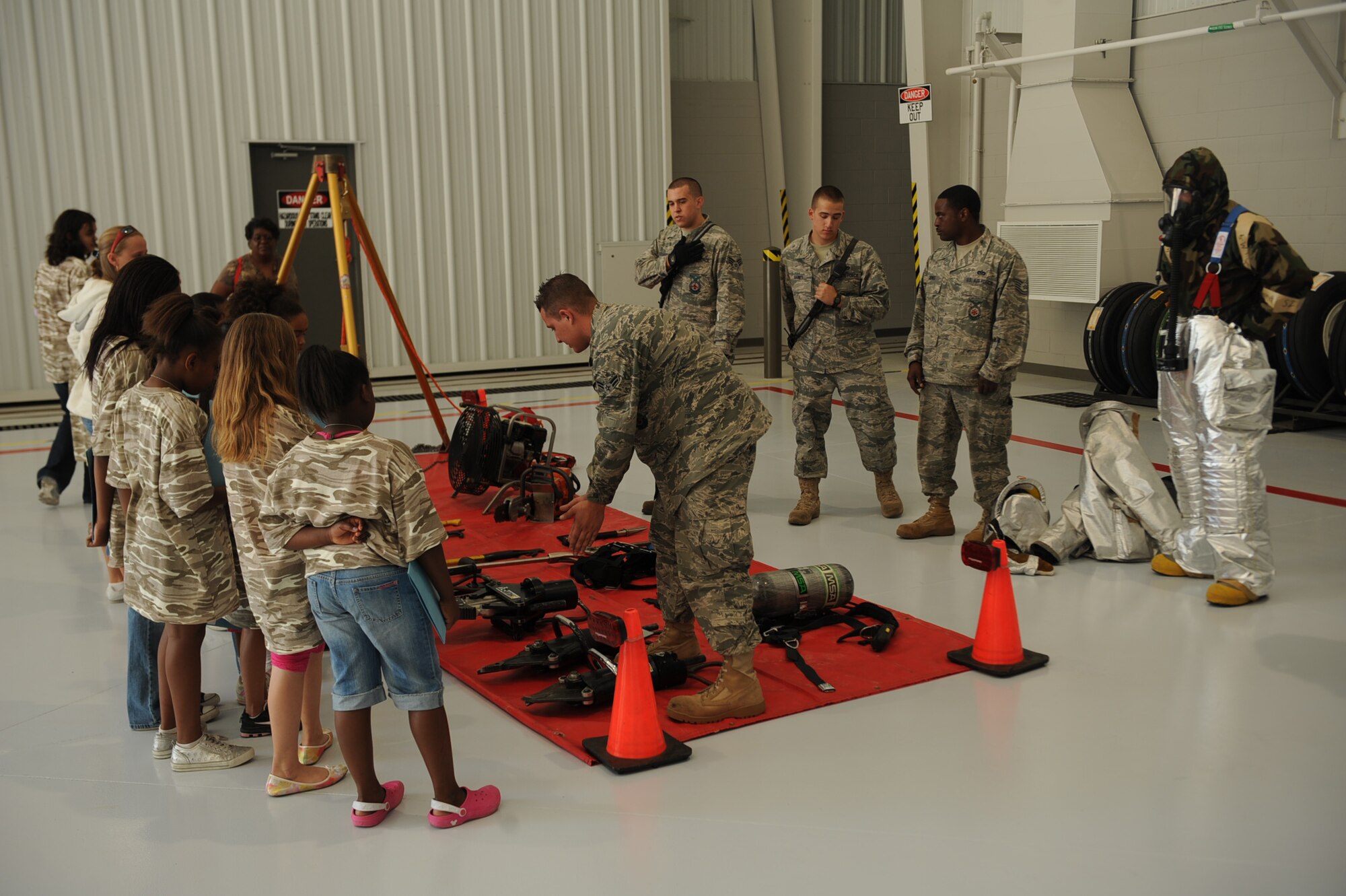 Participants of Operation Bug Out receive a briefing from base firefighters about different tools they use for fire safety, to fight fires and to save lives. More than 85 children participated in Operation Bug Out hosted by the Airman & Family Readiness Center. (U.S. Air Force photo/Senior Airman Ciara Wymbs) 