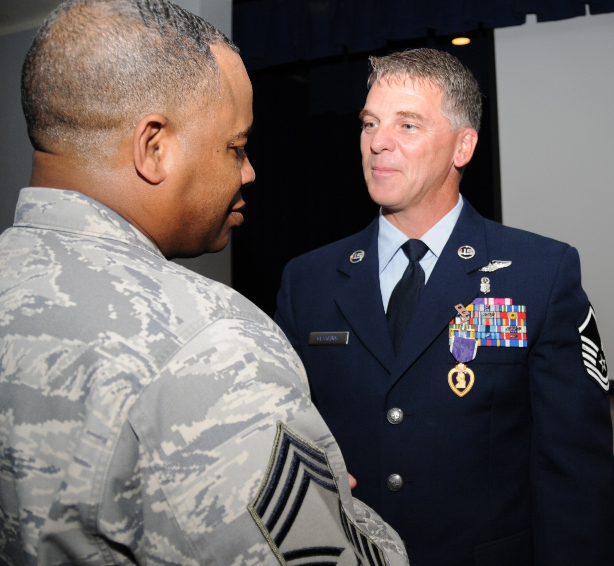Master Sergeant Kenneth Gestring, left, recipient of the Purple Heart May 4, is congratulated by Senior Master Sergeant Curtis Jennings, 81st Mission Support Group superintendent, after the ceremony at Keesler Medical Center.  Sergeant Gestring's wife, Corina, is in the center.  Sergeant Gestring, 81st Surgical Operations Squadron, received the award for wounds he suffered in January in Afghanistan.  (U.S. Air Force photo by Kemberly Groue)