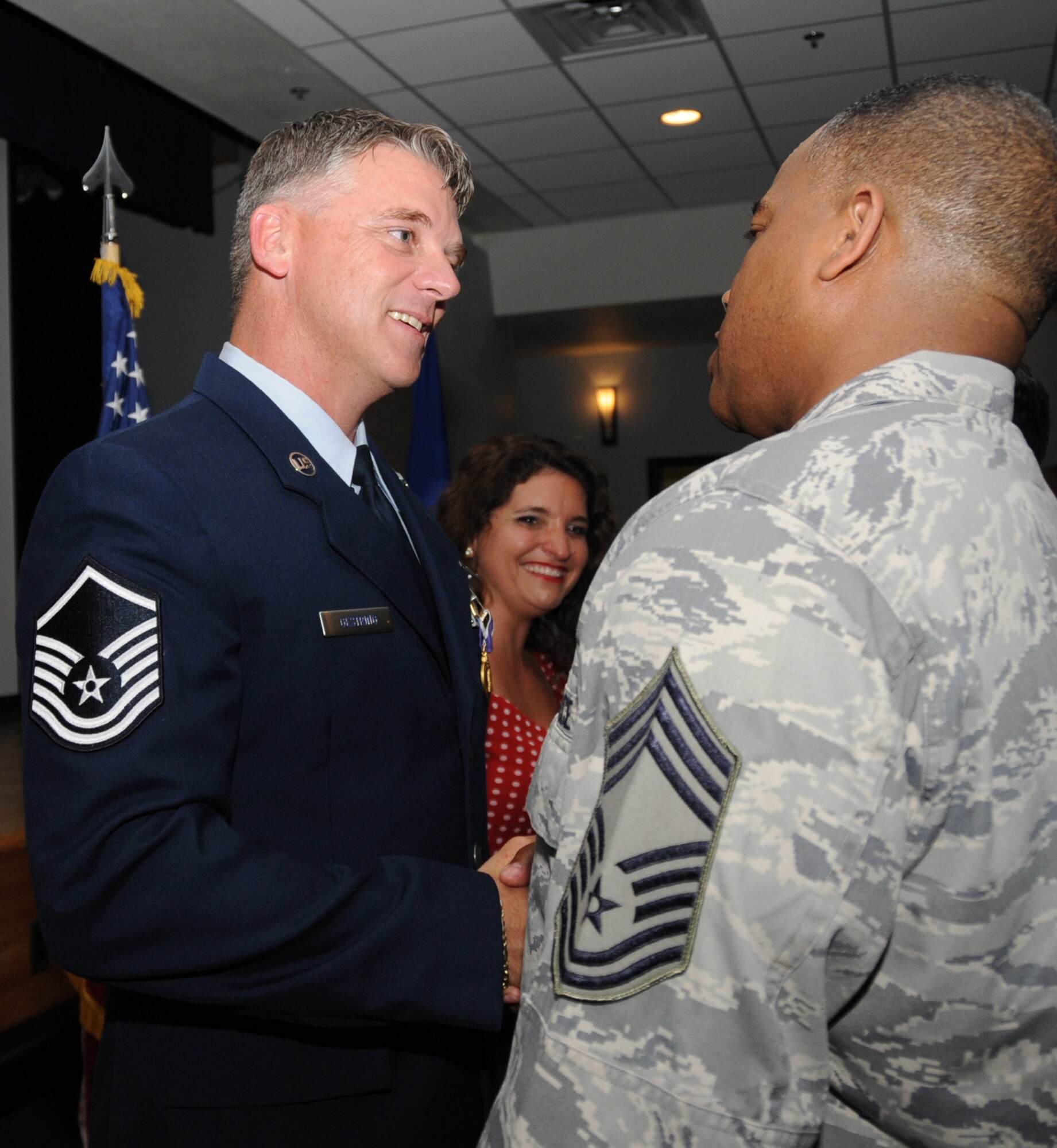 Master Sergeant Kenneth Gestring, left, recipient of the Purple Heart May 4, is congratulated by Senior Master Sergeant Curtis Jennings, 81st Mission Support Group superintendent, after the ceremony at Keesler Medical Center.  Sergeant Gestring's wife, Corina, is in the center.  Sergeant Gestring, 81st Surgical Operations Squadron, received the award for wounds he suffered in January in Afghanistan.  (U.S. Air Force photo by Kemberly Groue)