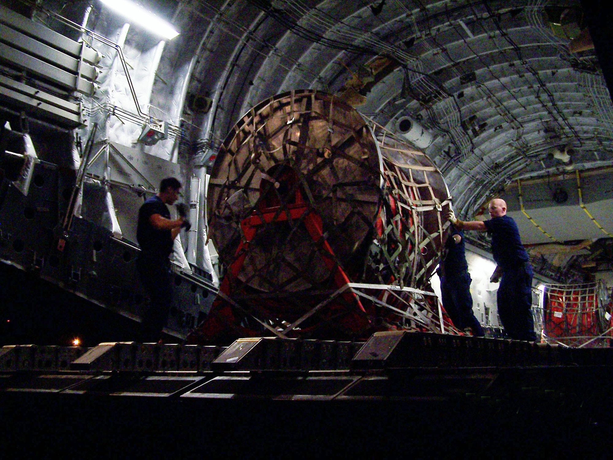 A Coast Guard crew offloads rolls of inflatable boom from a C-17 Globemaster III May 5, 2010 from Travis Air Force Base, Calif. Active duty and Air Force Reserve members from Travis AFB partnered with Coast Guard members May 2, 2010 to get equipment to the Gulf of Mexico to assist with oil clean up efforts. (U.S. Coast Guard photo/Lt. J.G. Michael Oubre)
