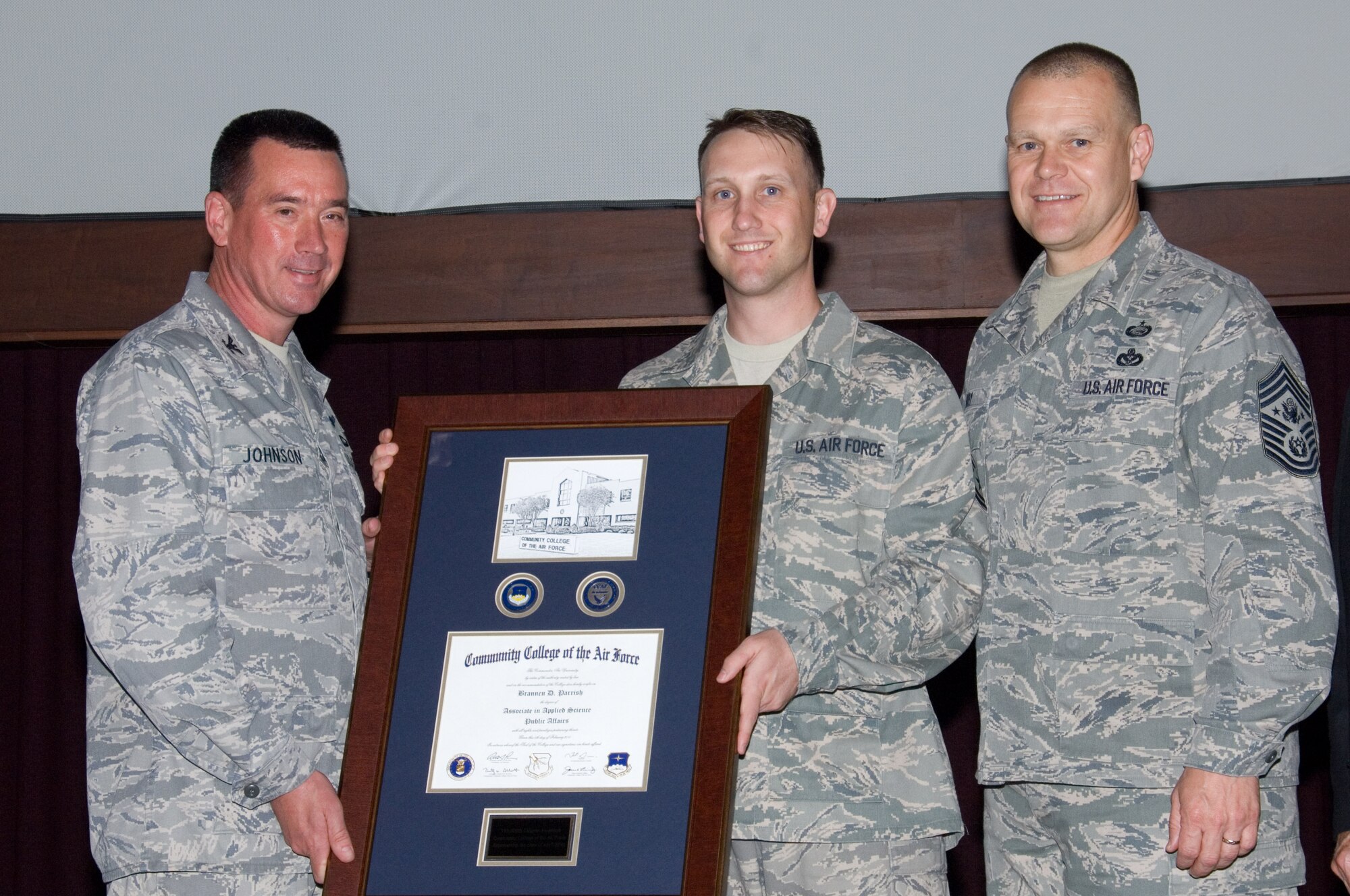 Technical Sgt. Brannen Parrish (center), Air University Public Affairs specialist, receives his Community College of the Air Force degree from Col. Charles W. Johnson (left), Barnes Center commander, and Chief Master Sgt. of the Air Force James A. Roy. Sergeant Parrish received the 350,000th CCAF degree. (Air Force photo/Melanie Rodgers Cox)