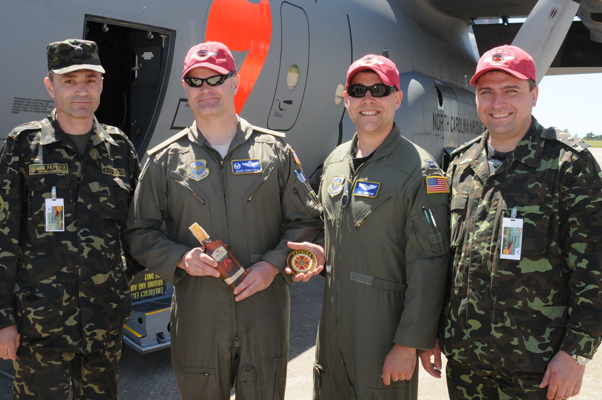 Col. Kozyrkov Ihor and colleague from the Ministry of Defense of Ukraine present North Carolina Air National Guard pilots Lt. Col. Mark Christan and Capt. Joel Kingdon with a bottle of specialty vodka, officer shoulder boards and a patch in appreciation of their flying skills demonstrated while observing a MAFFS drop from the ground during  the MAFFS training exercise in Greenville, SC. NCANG Photo by Staff Sgt. Richard Kerner. 
