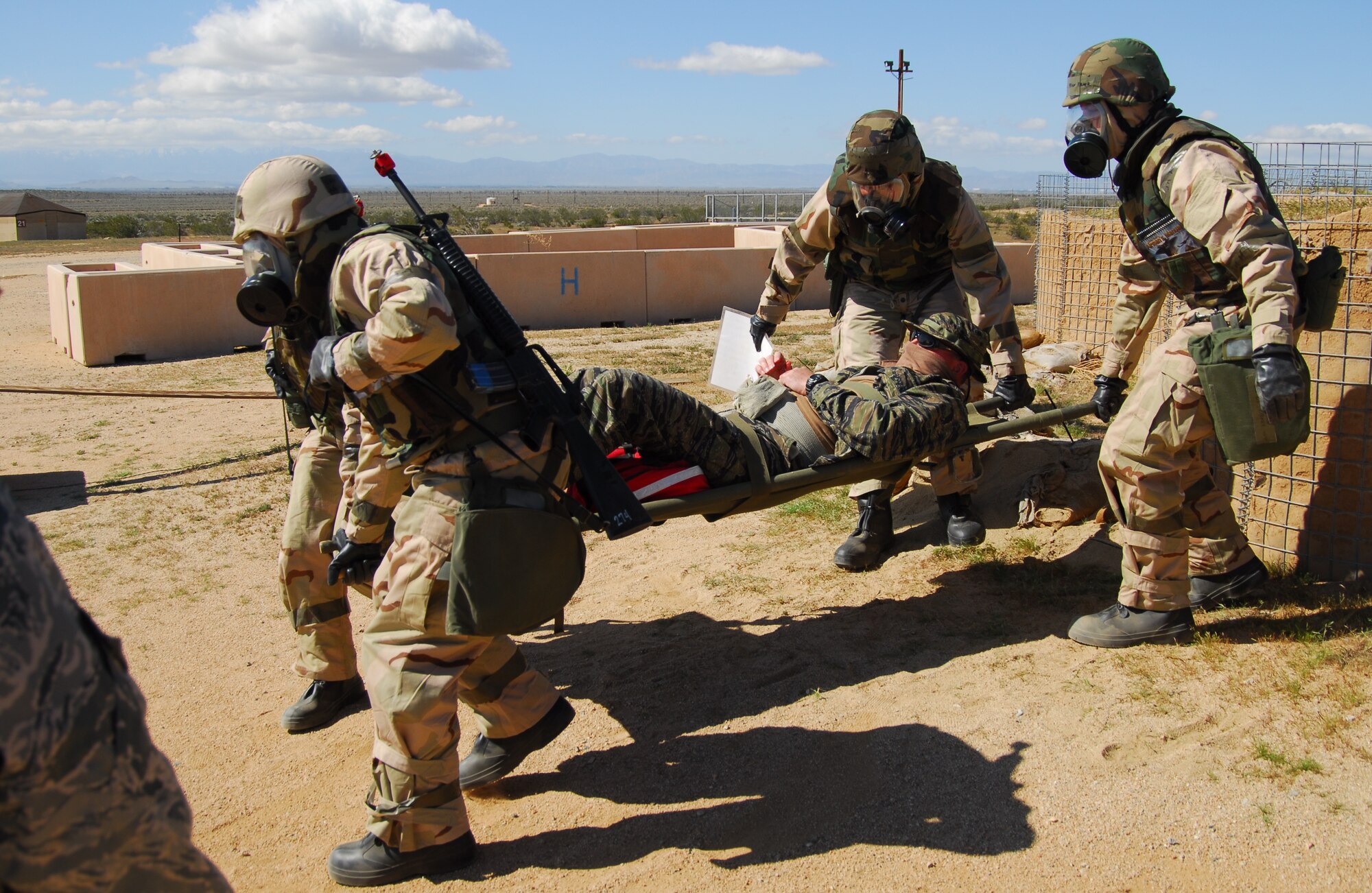 As part of the training at Camp Corum, personnel are taught proper stretcher bearer techniques.  Here, 95th Medical Group personnel carry a simulated victim to a safe area for treatment and preparation for possible follow-on transportation to a medical facility.  (Air Force photo by Stephen K. Robinson)