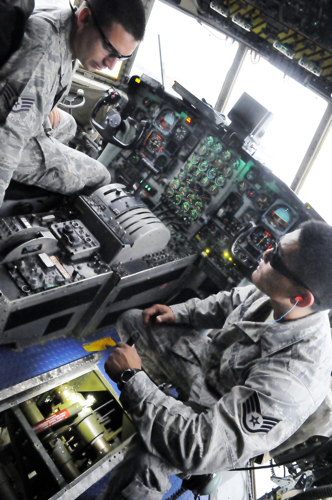 SSgts. Jeremiah McCoy and Michael Archangel, Hurlburt Field, Fla. check engine and flight control cables and levers in the flightdeck of a C-130 here. U. S. Air Force photo by Sue Sapp