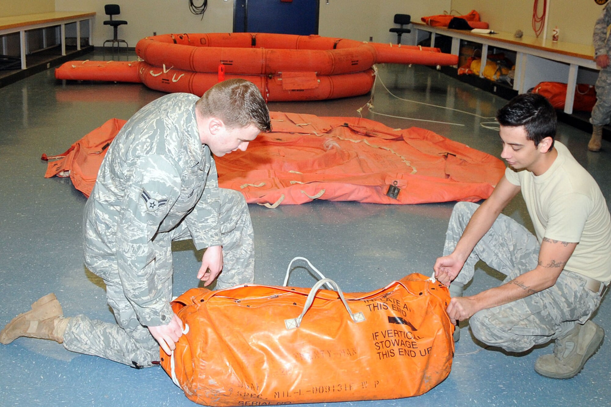OFFUTT AIR FORCE BASE, Neb. -- Airman 1st Class Andrew Carey, an aircrew flight equipment technician with the 55th Operations Support Squadron and Airman 1st Class Steven Cunningham, also an aircrew flight equipment technician with the 55th OSS, demonstrate the different stages of the F2B Life Raft here April 29. The raft can support 20 people and is also reversible. U.S. Air Force Photo by Kendra Williams