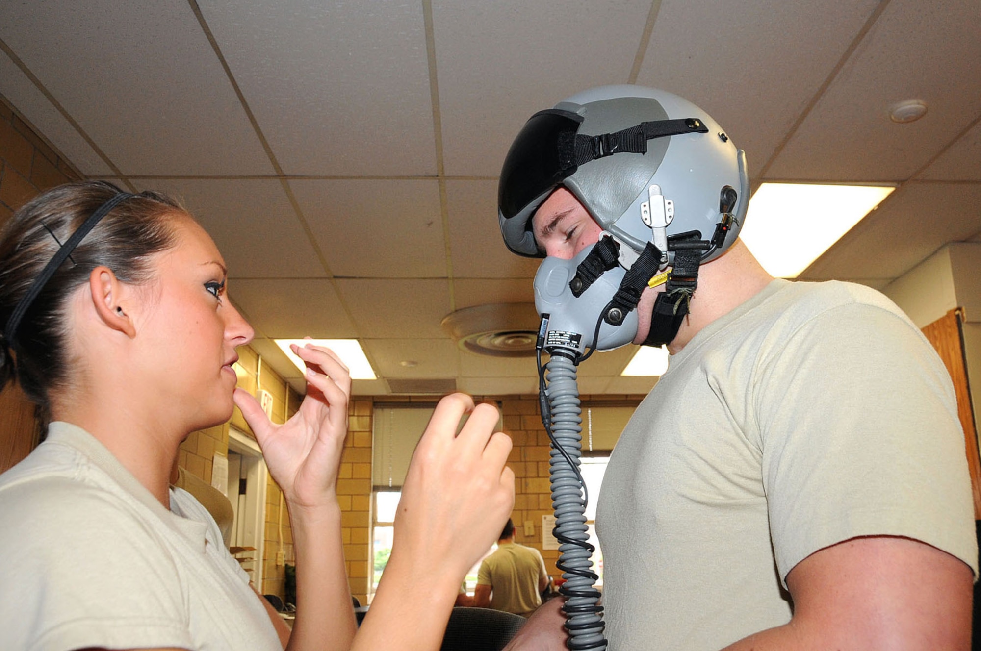 OFFUTT AIR FORCE BASE, Neb. -- Airman 1st Class Rebecca Wheeler, an aircrew flight equipment technician with the 55th Operations Support Squadron, instructs  Airman Devin Williams, also an aircrew flight equipment technician with the 55th OSS, on the proper fit of an HGU-55P (flyer's helmet) here April 29. The helmet is tested for normal and high altitudes before aircrews here deploy. U.S. Air Force Photo by Kendra Williams