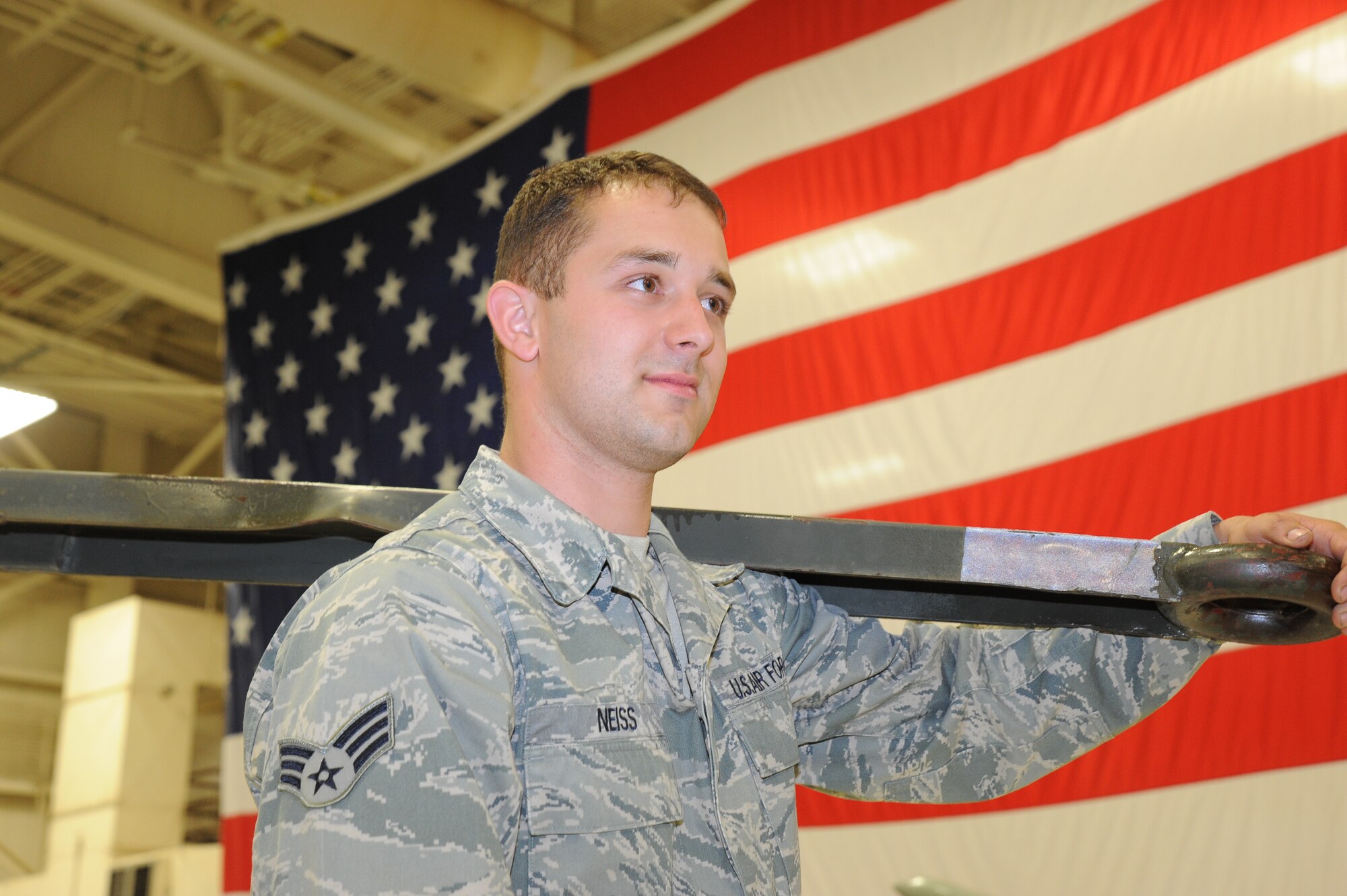 Senior Airman Jason Neiss, 22nd Maintenance Squadron aerospace ground equipment journeyman, carries a tow bar after the Knucklebusters Awards Banquet April 30, 2010, McConnell Air Force Base, Kan.  Maintenance parts and artifacts decorated the tables at the banquet.  More than 470 Team McConnell Airmen and family members attended the annual Knucklebusters Awards Banquet.  (U.S. Air Force photo/Tech. Sgt. Chyrece Campbell)
