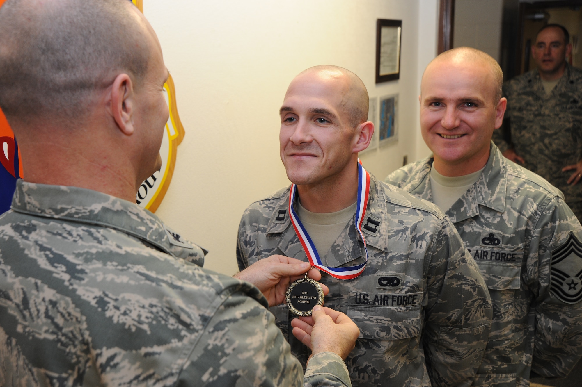 Capt. Jacob Sullivan, 22nd Aircraft Maintenance Squadron green aircraft maintenance unit OIC, receives his Knucklebusters Award nominee medal from Col. Allan Day, 22nd Maintenance Group commander, while Chief Michael Edward, 22nd Maintenance Group superintendent, observes April 30, 2010, McConnell Air Force Base, Kan.  Capt. Sullivan was one of 35 Team McConnell winners of McConnell’s 2010 Knucklebusters Award. The Knucklebuster banquet highlighted Team McConnell Airmen and their impact on McConnell’s mission.  (U.S. Air Force photo/Tech. Sgt. Chyrece Campbell)