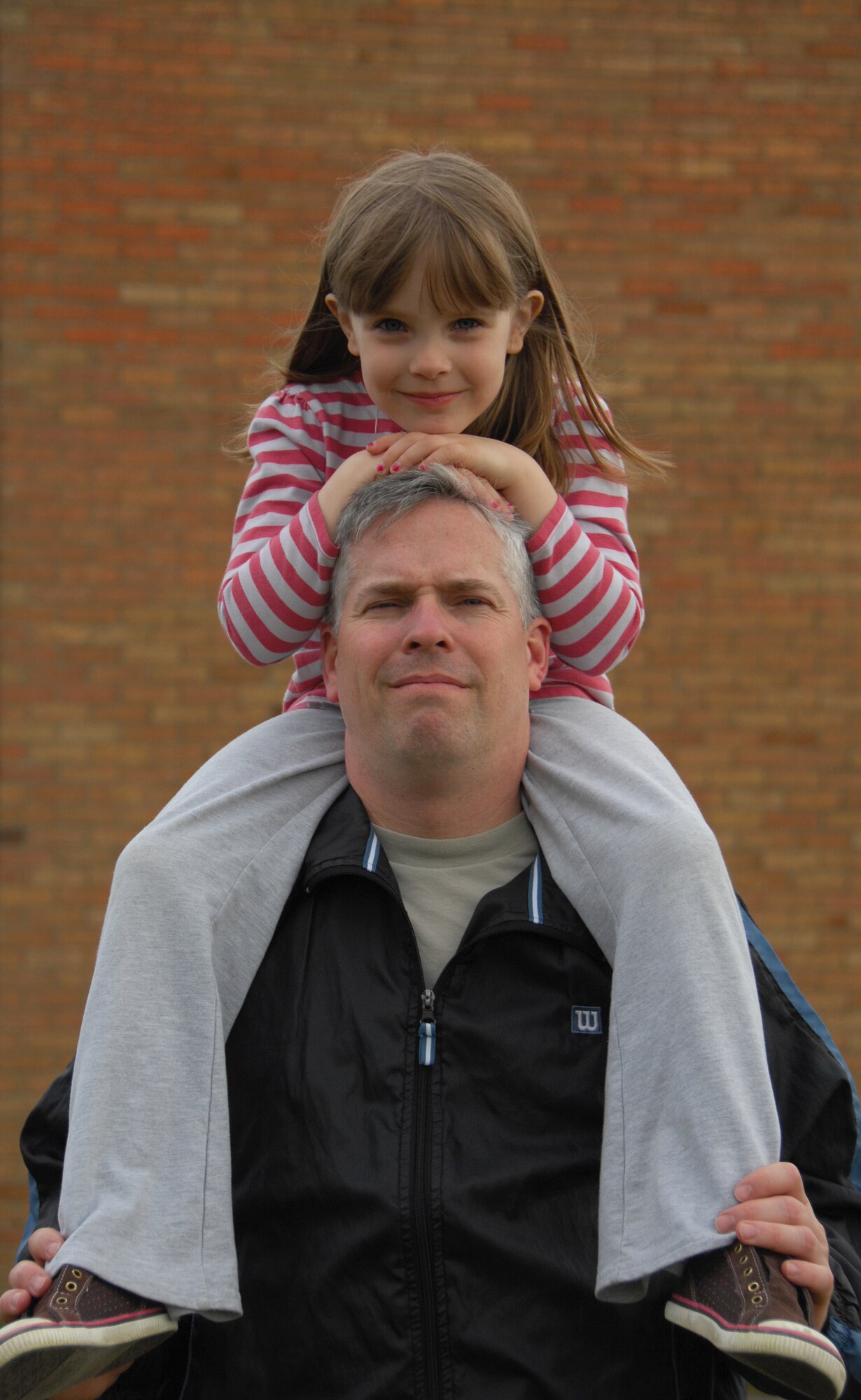 Tech. Sgt. Christopher A. Campbell, 48th Fighter Wing Public Affairs NCOIC of Internal operations poses with his daughter on his shoulders at RAF Lakenheath, May 5. Sergeant Campbell underwent surgery on both his shoulders after returning from a deployment. This was one of their favorite past-times before the surgery; it took a year to be able to carry his daughter again, to her delight. (U.S. Air Force photo/Alexander Campbell)
