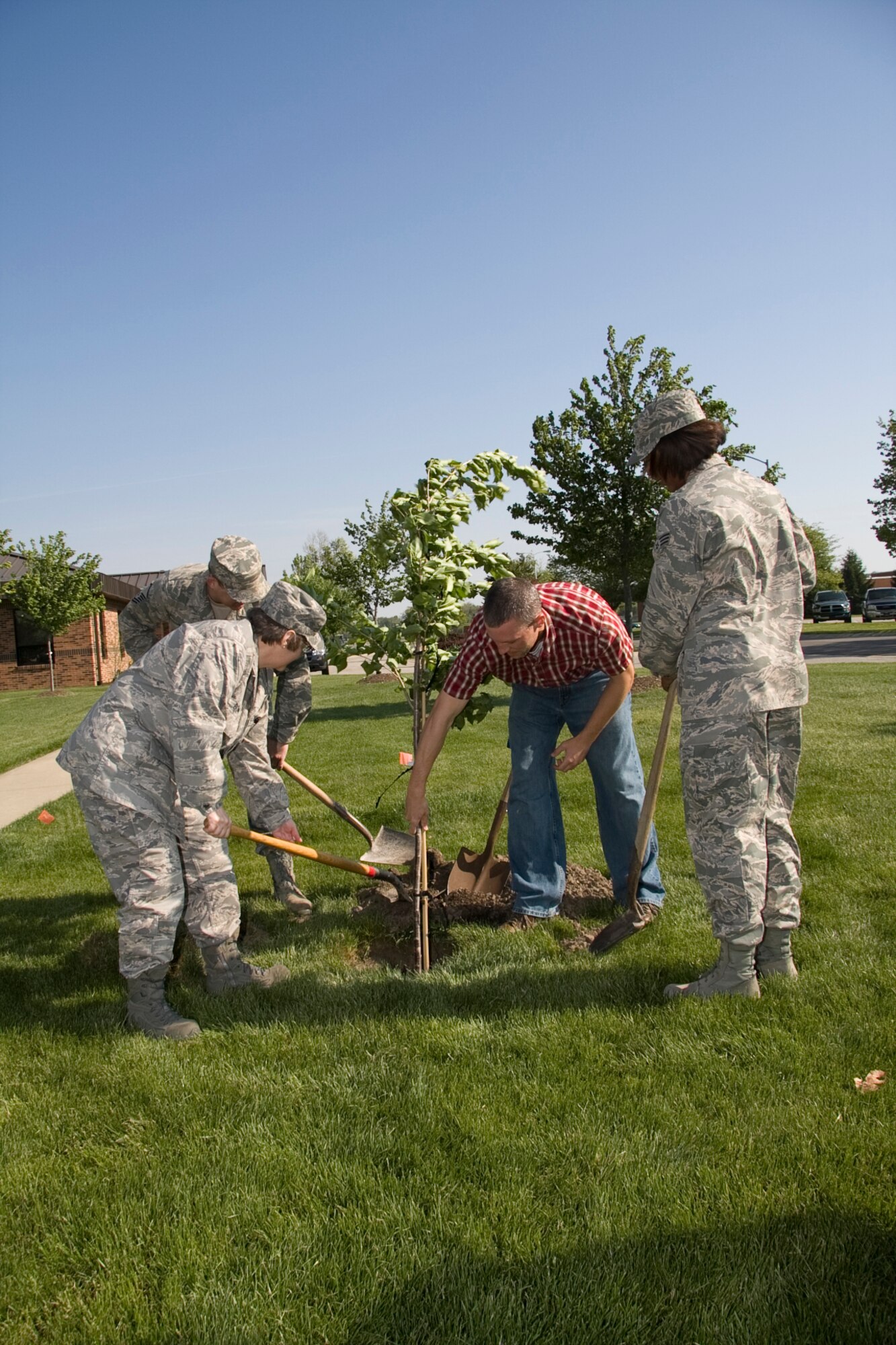 GRISSOM AIR RESERVE BASE, Ind. -- Col. Betty Bowen, Master Sgt. Christopher Rust, Senior Airman Jamia Nalls and Cory Walters plant a tree outside of the base civil engineer building during an Arbor Day ceremony held here recently. Because of Grissom's dedication to maintaining the urban forest and the environment, the base was recently named a Tree City USA for the ninth straight year by the National Arbor Day Foundation. Colonel Bowen is the 434th Mission Support Group commander. Sergeant Rust, Airman Nalls and Mr. Walters are with the 434th Civil Engineer Squadron. (U.S. Air Force photo/Tech. Sgt. Mark R. W. Orders-Woempner)