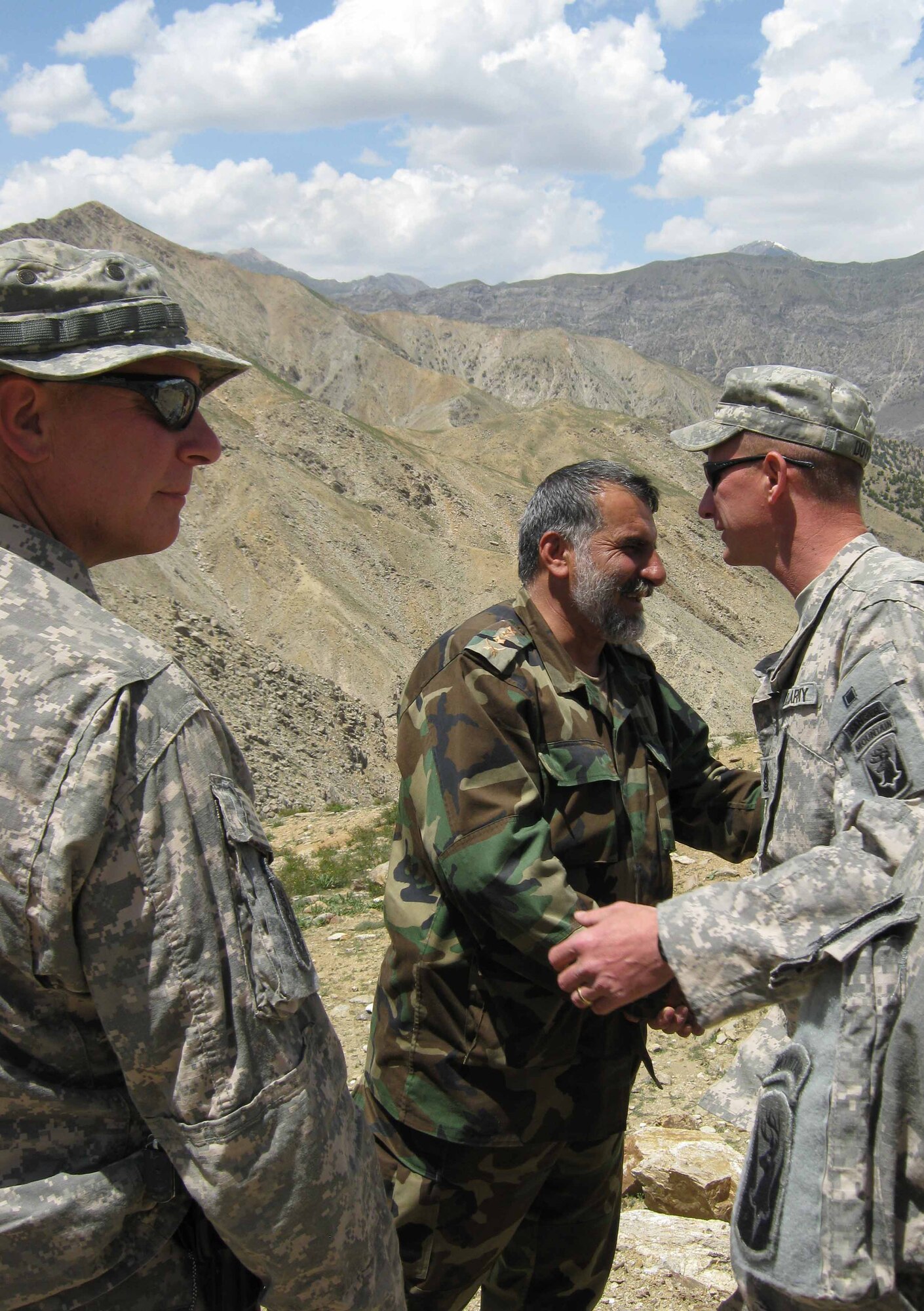 PANJSHIR PROVINCE, Afghanistan ? Afghan National Army Col. Rajab Khan, commander of the Panjshir Operations Coordination Center (Provincial), greets Sgt. Maj. Scott Doyon, Task Force Wolverine Panjshir OCC-P Embedded Training Team. A group of military and civilian members from Provincial Reconstruction Team Panjshir had a lunch together on a mountain at Darban Pass April 29. The group talked about the future of Afghanistan and how they can continue their strong partnership. (Photo by U.S. Air Force 2nd Lt. Jason Smith, Provincial Reconstruction Team Panjshir Public Affairs)