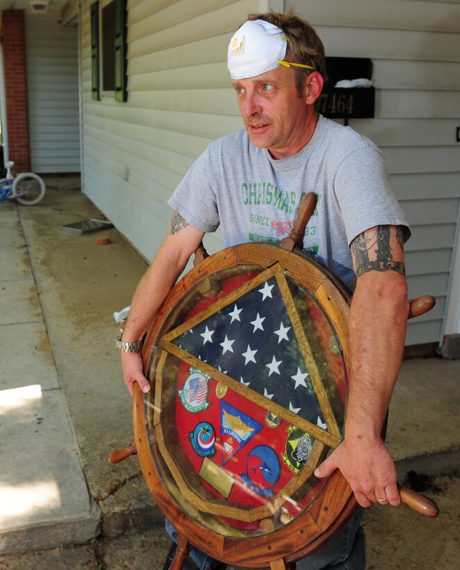 U.S. Navy housing resident Larry Stivers salvages his retirement shadow box after being allowed back to his home in the base housing area of Naval Support Activity Mid-South in Millington, Tenn., May 5, 2010.