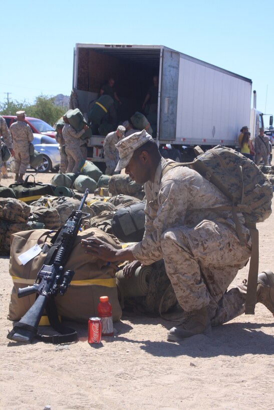 Lance Cpl. Jarvis Burton, a field operator with Battery L, 3rd Battalion, 11th Marine Regiment, adjusts his pack one last time before boarding the bus and the beginning of a seven-month deployment to Afghanistan in support of Operation Enduring Freedom, May 7.::r::::n::