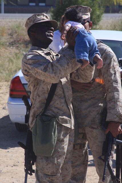 Lance Cpl. Nigel Warren, a field artillery cannoneer with Battery L, 3rd Battalion, 11th Marine Regiment, holds his infant daughter, Adlina, just before boarding the bus and the beginning of a seven-month deployment to Afghanistan in support of Operation Enduring Freedom May 7. ::r::::n::