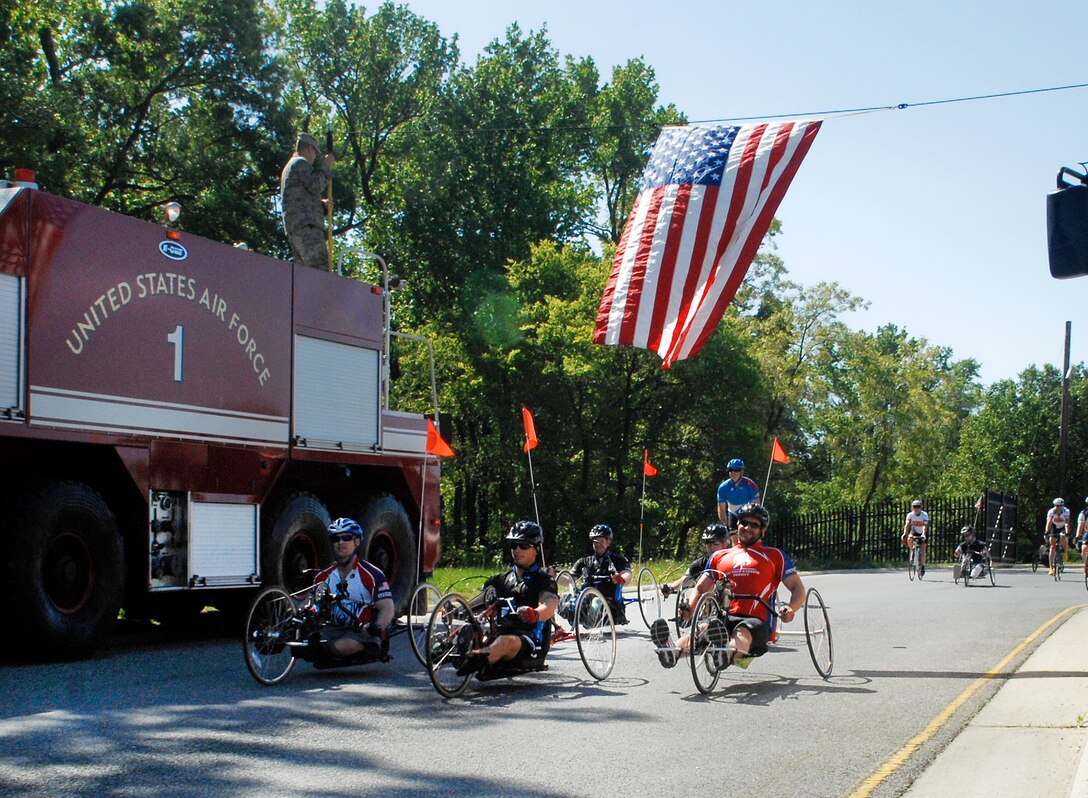 The first wave of wounded warrior cyclists roll past a 316th Civil Engineer Squadron fire truck on their way out of Joint Base Andrews’ North Gate to cheers of encouragement from on-lookers during the 4th Annual Wounded Warrior Project’s Soldier Ride, which started April 28, 2010, at the White House and ended Saturday in Annapolis, Md. (U.S. Air Force photo by Senior Airman Melissa Brownstein)