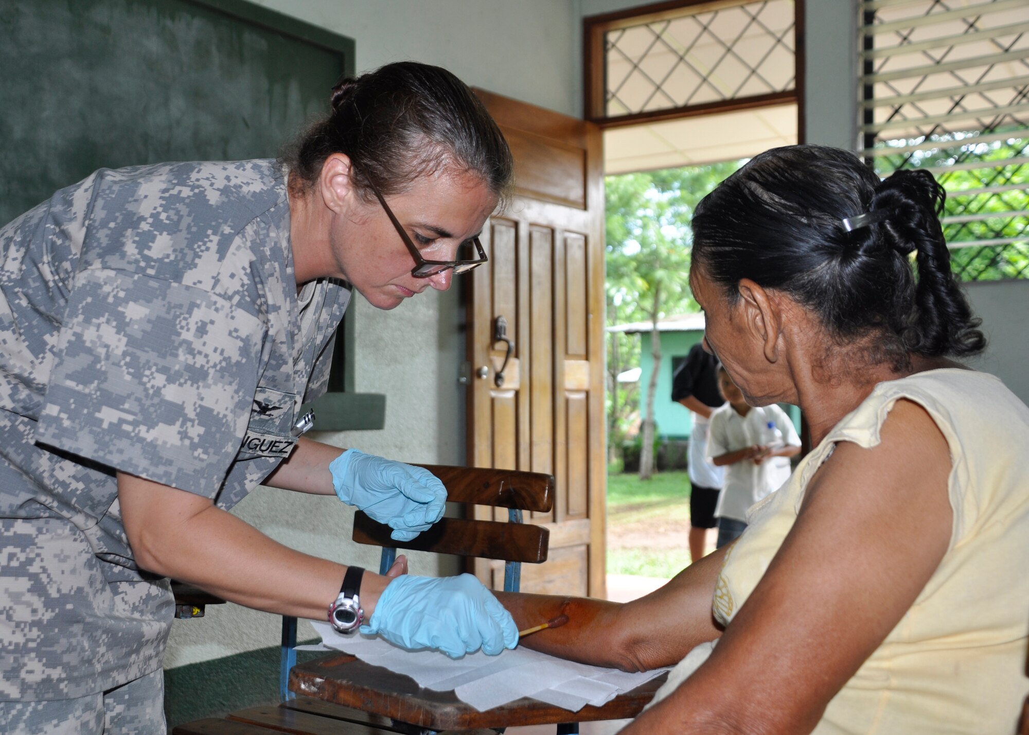 Colonel Marie Domiguez, Medical Element commander, cleans a wound site before performing an exploratory procedure May 5 in El Ayote, Nicaragua. The medical civic action program team came together to treat more than 1,100 patients with a variety of illnesses including stomach pains, chest colds, skin rashes, and other illnesses May 3-6.(U.S. Air Force photo by Staff Sgt. Bryan Franks)