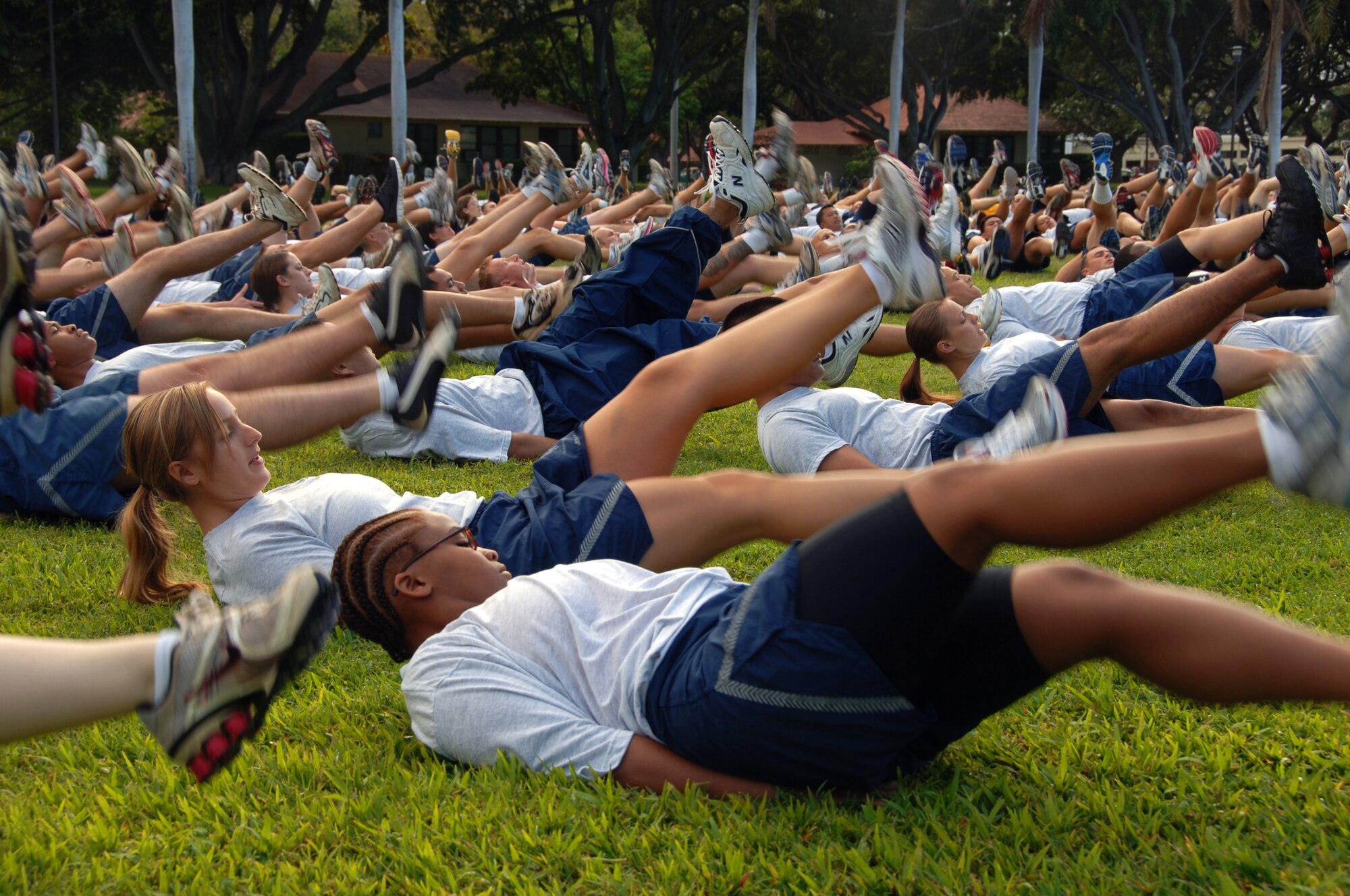 Airmen perform flutter kicks as a warm up exercise for the "Warrior Run" May 7 at Joint Base Pearl Harbor Hickam, Hi. Participants were addressed by Col. Giovanni Tuck, 15th Airlift Wing Commander before beginning the run - Col. Tuck's last as 15th AW commander. (U.S. Air Force photo by Senior Airman Nathan Allen)