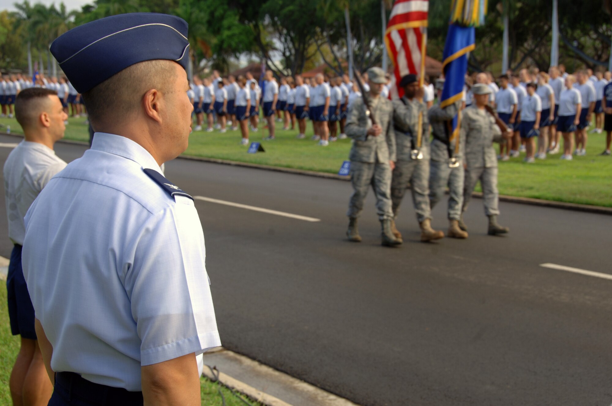 Col. Giovanni Tuck, 15th Airlift Wing commander, observes the honor guard prepare to present the colors before the "Warrior Run" May 7 at Joint Base Pearl Harbor Hickam, Hi. The run was the last Col. Tuck will be a part of as commander of the 15th AW. (U.S. Air Force photo by Senior Airman Nathan Allen)