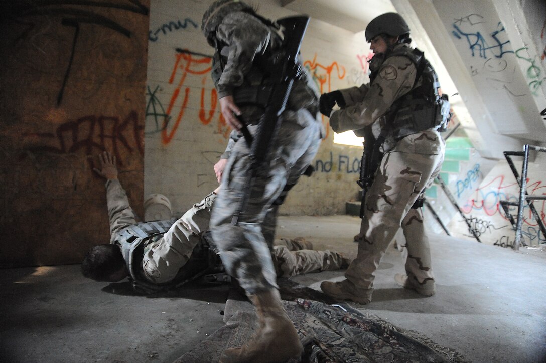Second Lt. Alea Nadeem neutralizes the threat posed by DoD Officer Steven Haymes, playing an armed suspect, while Officer Yvette Perez provides coverage during the military operations in urban terrain (MOUT) training April 22. They are part of the 61st Security Forces Squadron team competing in this year's Guardian Challenge May 16 through 19 at the Air Force Space Command in Colorado Springs, Colo. (Photo by Joe Juarez)