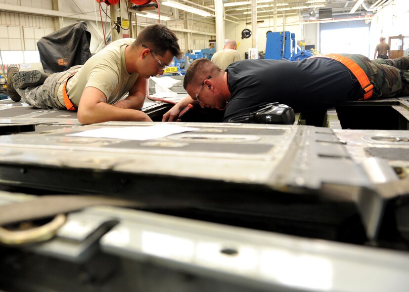 DYESS AIR FORCE BASE, Texas -  Airman 1st Class Christopher Greene (left), and Senior Airman Jacob "Pirate" Collins, both from the 7th Equipment Maintenance Squadron, repair a C-130 Hercules cargo ramp May 6 here. The Airmen provide support for both the B-1 Bomber and C-130, insuring they are structurally sound and mission ready. (U.S. Air Force photo/ Airman 1st Class Chelsea Browning)