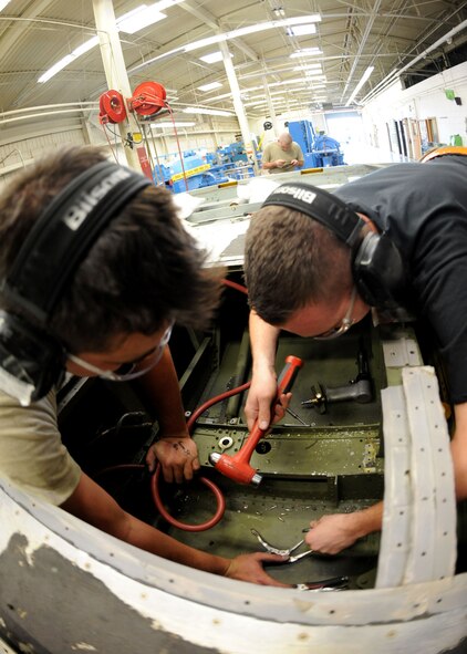 DYESS AIR FORCE BASE, Texas -  Airman 1st Class Christopher Greene (left), and Senior Airman Jacob "Pirate" Collins, both from the 7th Equipment Maintenance Squadron, repair a C-130 Hercules cargo ramp May 6 here. The Airmen provide support for both the B-1 Bomber and C-130, insuring they are structurally sound and mission ready. (U.S. Air Force photo/ Airman 1st Class Chelsea Browning)