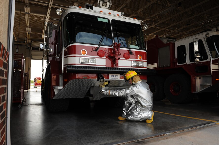DYESS AIR FORCE BASE, Texas-- Airman 1st Class Jacob Strachan, 7th Civil Engineer Squadron firefighter, inspects a water hose May 6 under a fire truck here. There are more than 55 firefighters within the squadron who operate more than 15 fire trucks. Some days they have up to 10 calls and are required to be on scene within five minutes of the call. Firefighters keep everyone on the base as safe as possible by conducting routine safety checks on the buildings as well as practicing what to do in case of a fire.  (U.S Air Force photo/ Airman 1st Class Shannon Hall)
