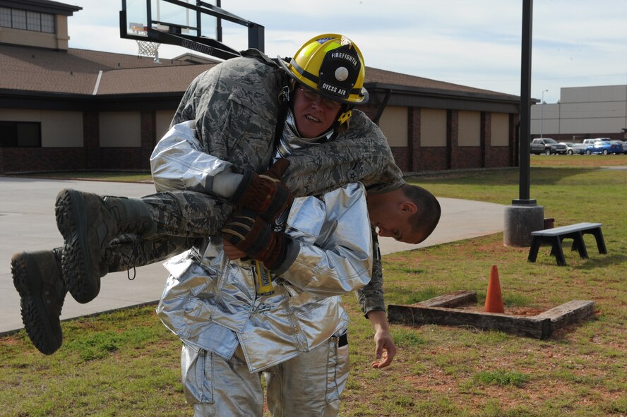 DYESS AIR FORCE BASE, Texas-- Airman 1st Class Brett Williams, 7th Civil Engineer Squadron firefighter, demonstrates the fireman carry May 6 using Airman Zachariah Weldon, also a firefighter, during a training exercise here. There are more than 55 firefighters within the squadron who operate more than 15 fire trucks. Some days they have up to 10 calls and are required to be on scene within five minutes of the call. Firefighters keep everyone on the base safe by conducting routine safety checks on buildings as well as practicing what to do in case of a fire. (U.S Air Force photo/ Airman 1st Class Shannon Hall)
