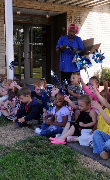 BARKSDALE AIR FORCE BASE, La. -- Toni Whitaker, Barksdale Child Development Center instructor, passes out pinwheels for children from to place in the ground before the Military Child Carnival at the Barksdale CDC April 29. The children planted more than 20 pinwheels in front of the CDC. This event was held in support of the National Month of the Military Child. (U.S. Air Force photo by Senior Airman La’Shanette V. Garrett) (RELEASED)