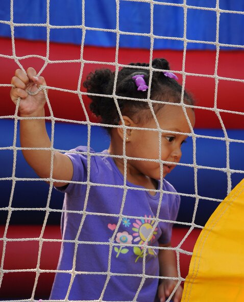BARKSDALE AIR FORCE BASE, La. -- Samaya Buckingham, 2, holds on as she waits her turn to exit the bouncy house during the Military Child Carnival held at the Barksdale Child Development Center April 29. This event was held in support of the National Month of the Military Child. Samaya is the daughter of Brandy Johnson. (U.S. Air Force photo by Senior Airman La’Shanette V. Garrett) (RELEASED)