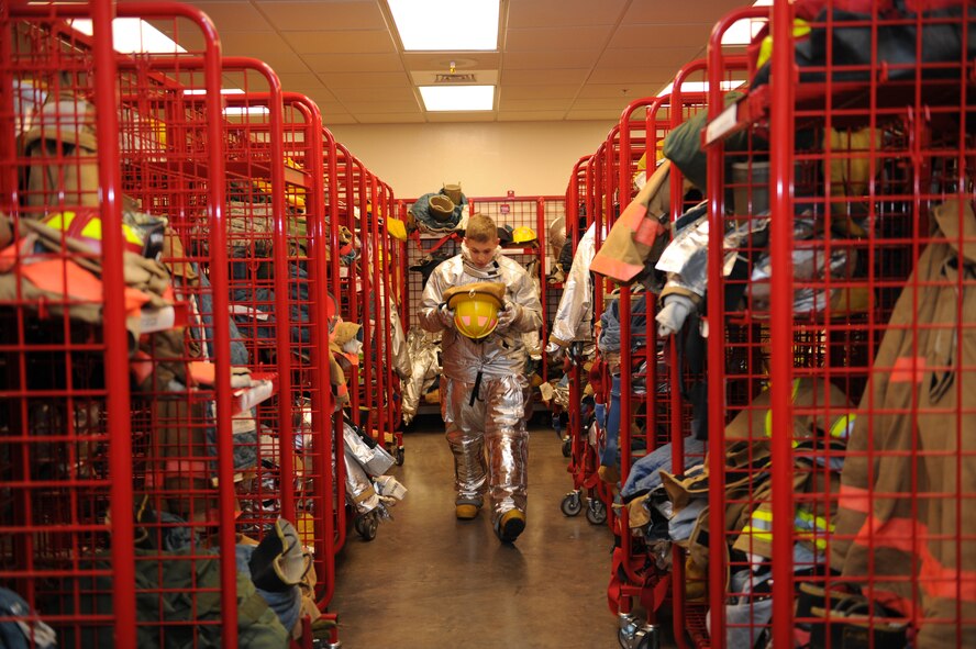 DYESS AIR FORCE BASE, Texas-- Airman 1st Class Jacob Strachan, 7th Civil Engineer Squadron firefighter, dons his fire-prevention gear May 6 here.  There are more than 55 firefighters within the squadron who operate more than 15 fire trucks. Some days they have up to 10 calls and are required to be on scene within five minutes of the call. Firefighters keep everyone on the base as safe as possible by conducting routine safety checks on the buildings as well as practicing what to do in case of a fire.  (U.S Air Force photo/ Airman 1st Class Shannon Hall)
