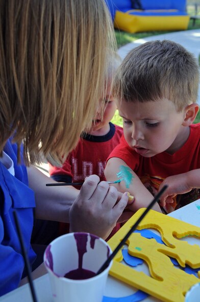 BARKSDALE AIR FORCE BASE, La. -- Riley Siena, 2, waits patiently as he gets a dinosaur painted on his arm during the Military Child Carnival held at the Barksdale Child Development Center April 29. This event was held in support of the National Month of the Military Child. Riley is the son of Senior Airman Russell Fenimore, 2d Munitions Squadron and Staff Sgt. Tiffani Siena, 917th Operations Group. (U.S. Air Force photo by Senior Airman La’Shanette V. Garrett) (RELEASED)