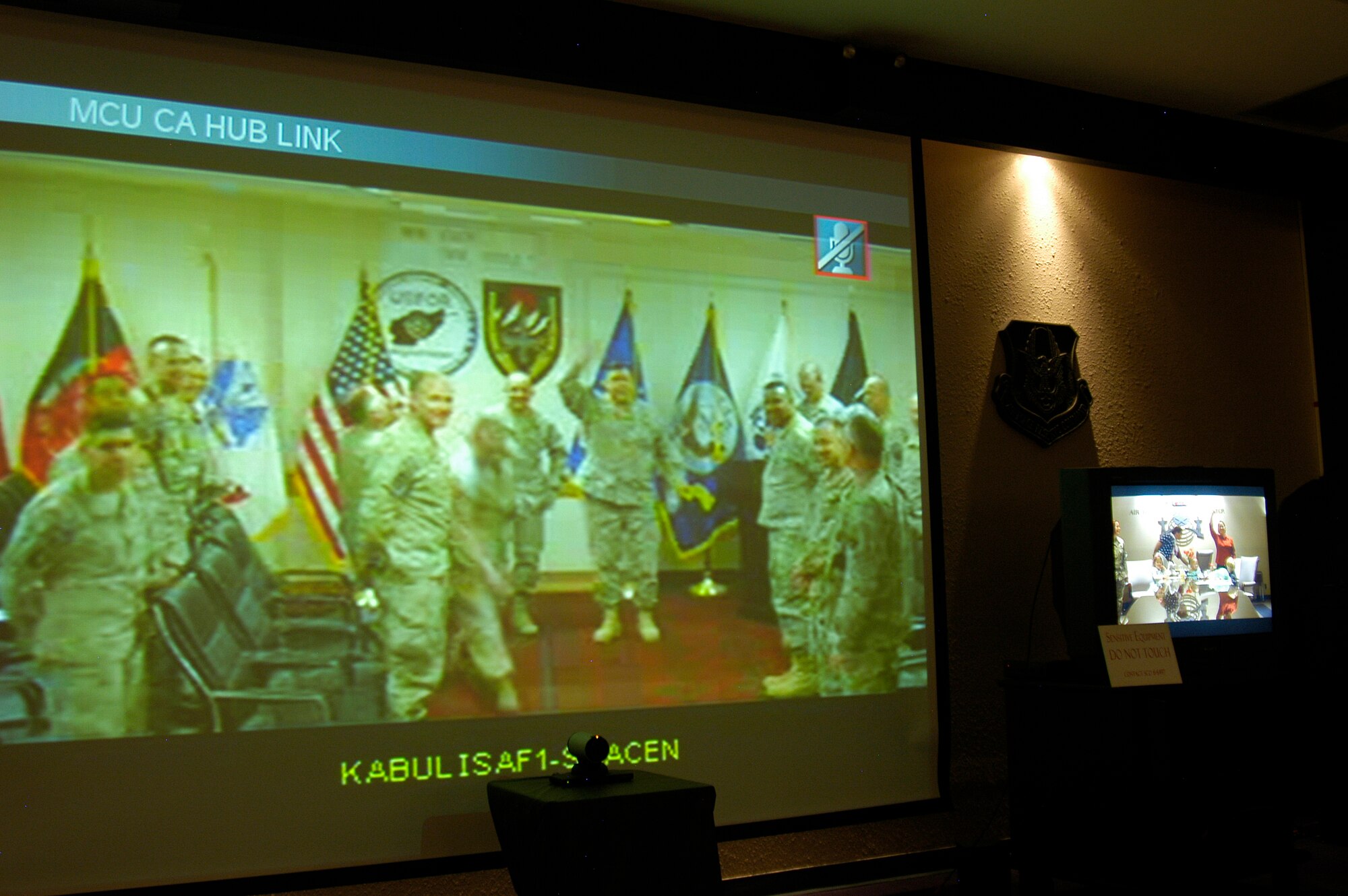 Military members from the United States Joint Forces Command, Forward Support Element in Afghanistan are seen via video teleconference in ARPC's Schwing Conference Room on April 30. Stephanie Thomas, and her family, watched by VTC as her brother Col. Willliam Robinson was promoted in a ceremony in Afghanistan. (U.S. Air Force photo/Erline Rohan)                                 